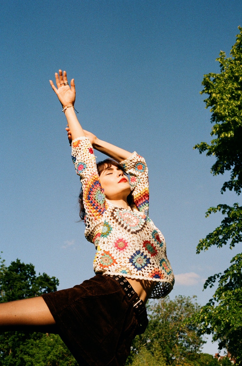 a woman is reaching up to catch a frisbee